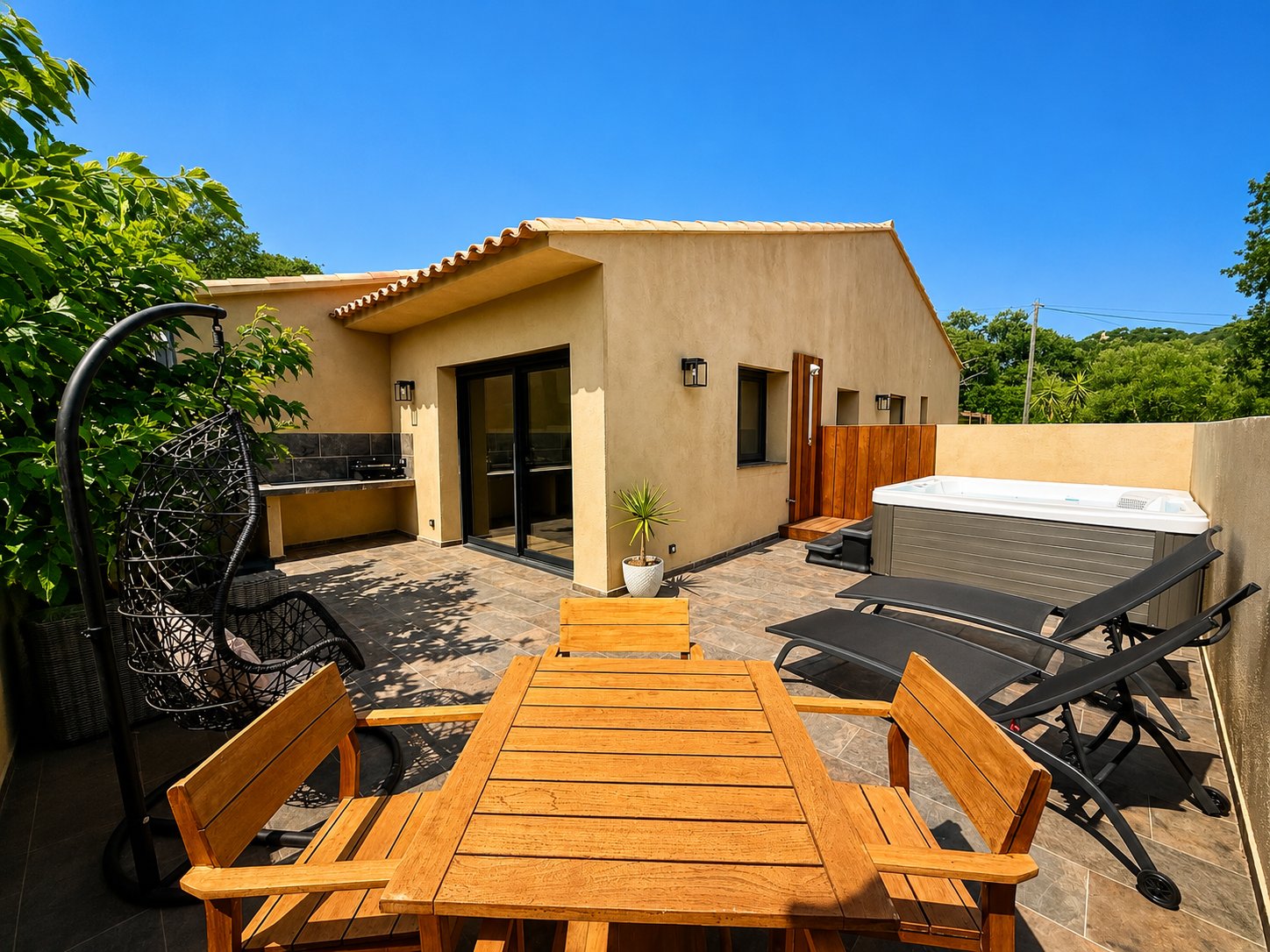 Terrasse de la Villa Folacca avec jacuzzi privatif, transats et coin repas en bois