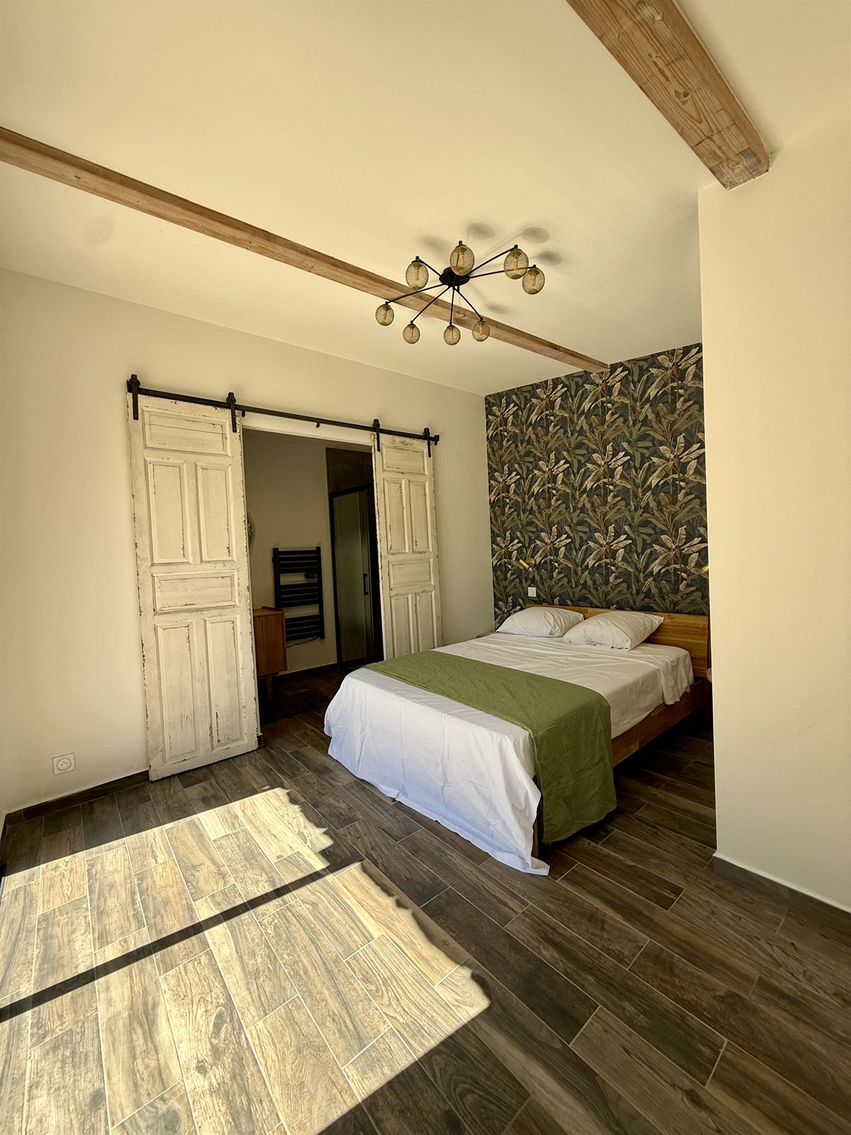 Chambre baignée de lumière naturelle, parquet et poutres apparentes — Villa Palombaggia