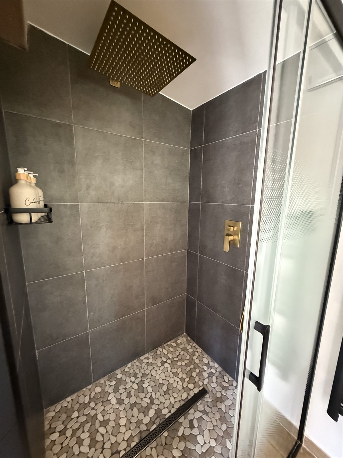 Douche à l'italienne, pomme de douche dorée et sol en galets — Villa Palombaggia