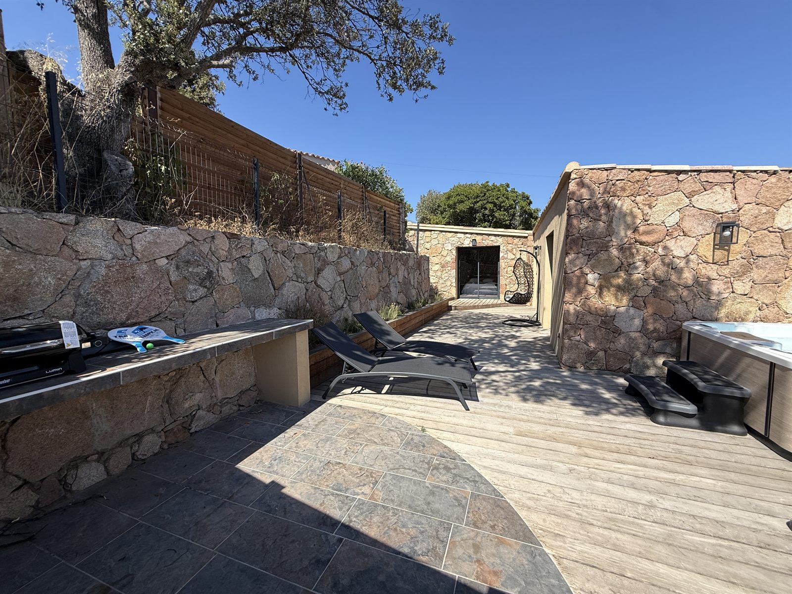 Terrasse en bois avec transats et jacuzzi, à l'abri des regards — Villa Palombaggia