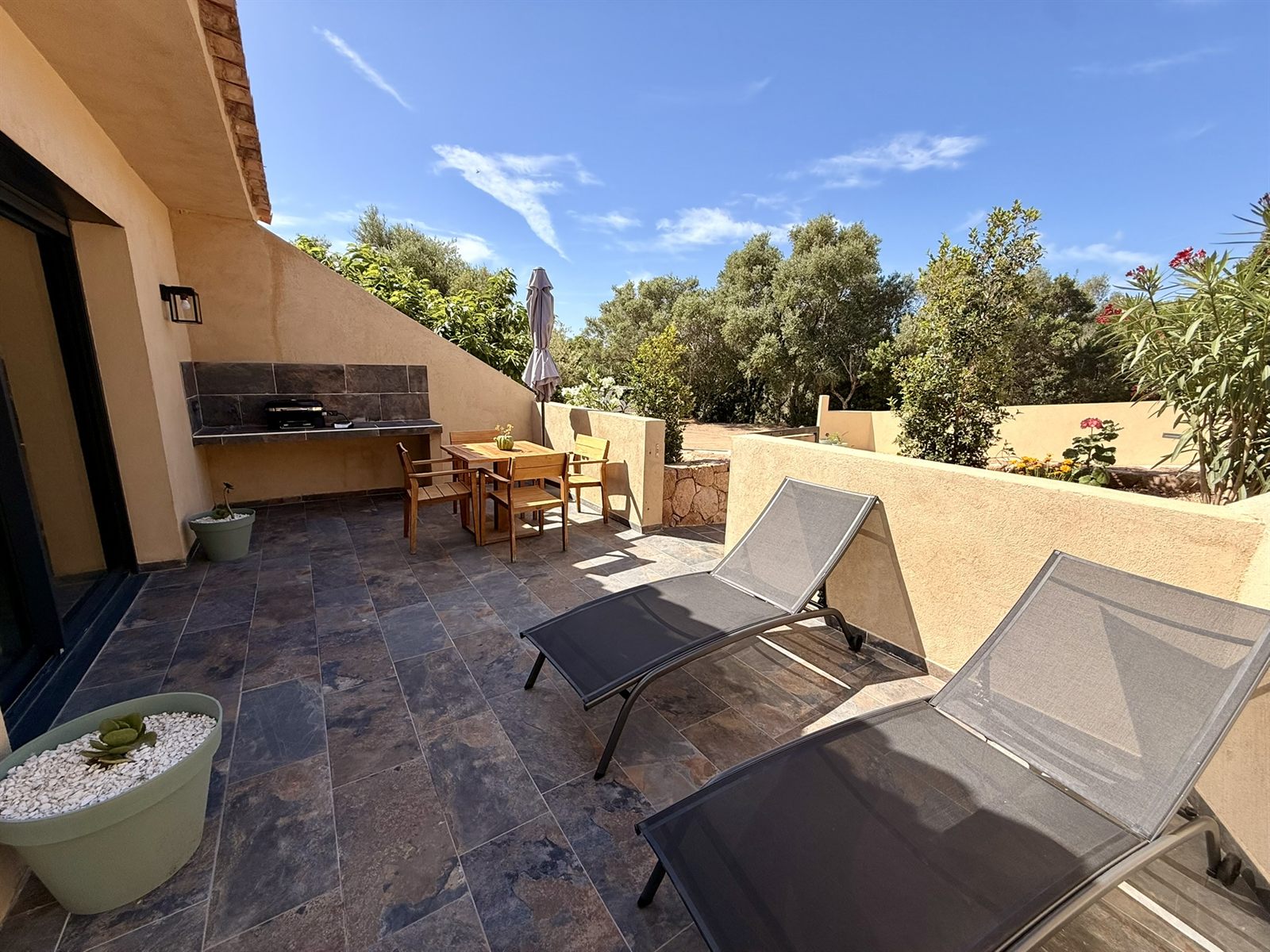 Terrasse ensoleillée avec transats, coin repas et barbecue Weber — Villa Tamaricciu